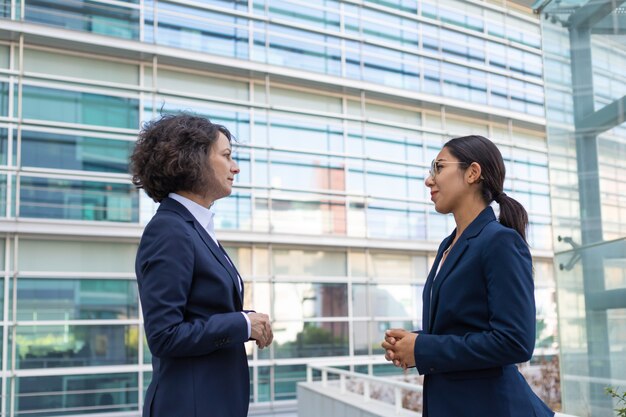 Two business ladies discussing project near office