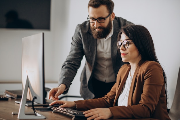 Two business partners working together in office on computer