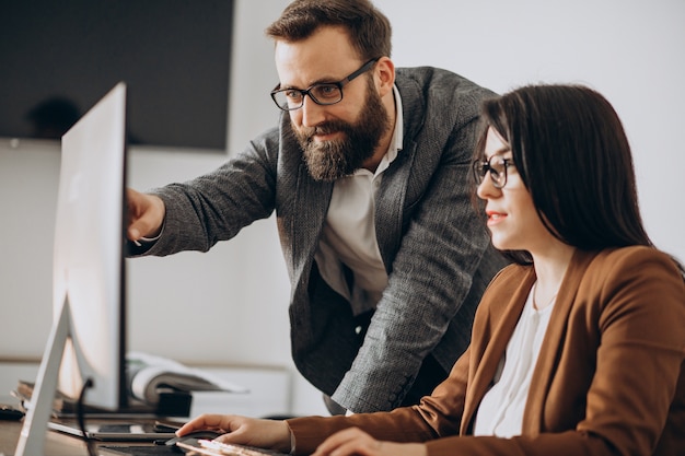 Two business partners working together in office on computer