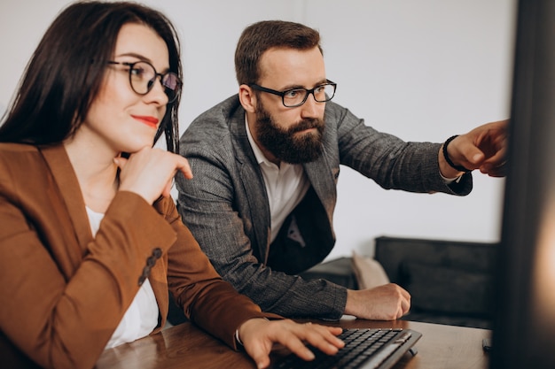 Two business partners working together in office on computer