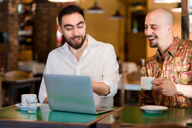 Free photo two business people using a laptop during a meeting at a coffee shop. business concept.