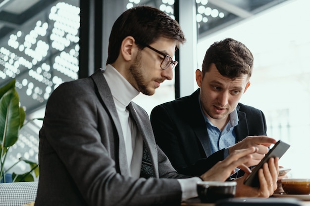 Free photo two businessmen having a conversation using a smartphone