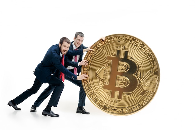 Free photo two businessmen holding bitcoin