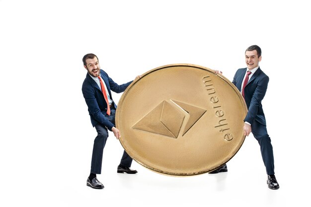 Two businessmen holding business icon - big ethereum isolated on white background. Cryptocurrency, bitcoun, litecoin, e-commerce, finance concept. Collage