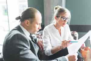 Free photo two businesspeople examining document in caf�