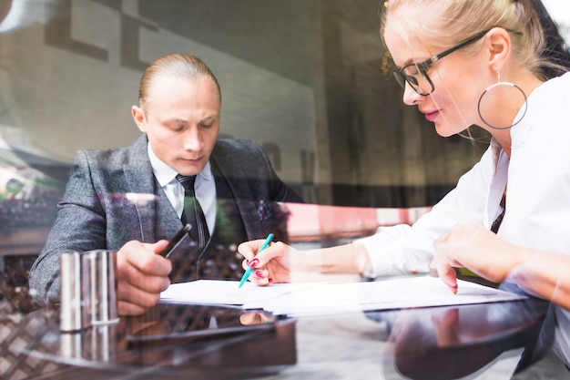 Free photo two businesspeople examining document in restaurant