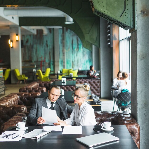 Two businesspeople looking at document in caf�