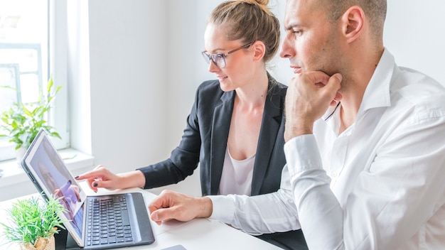 Two businesspeople working on laptop at workplace