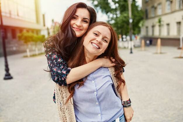 Two cheerful sisters hugging