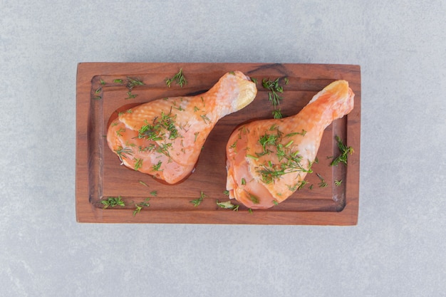 Free Photo two chicken drumstick and sliced lemon, on the blue surface