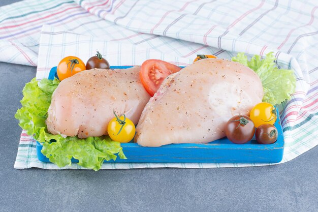 Two chicken fillets on blue plate.