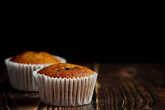 Two chocolate muffins put on wooden floor