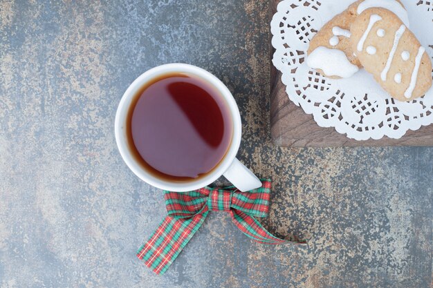 Two Christmas cookies and cup of tea on marble background. High quality photo