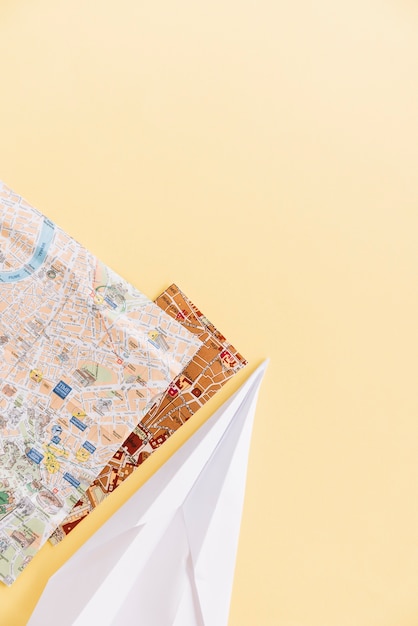 Free Photo two city maps with handmade paper airplane on the corner of the background