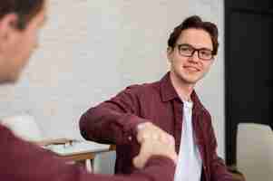 Free photo two classmates fist bumping each other during group study