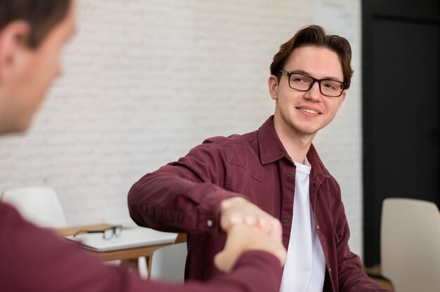 Free Photo two classmates fist bumping each other during group study