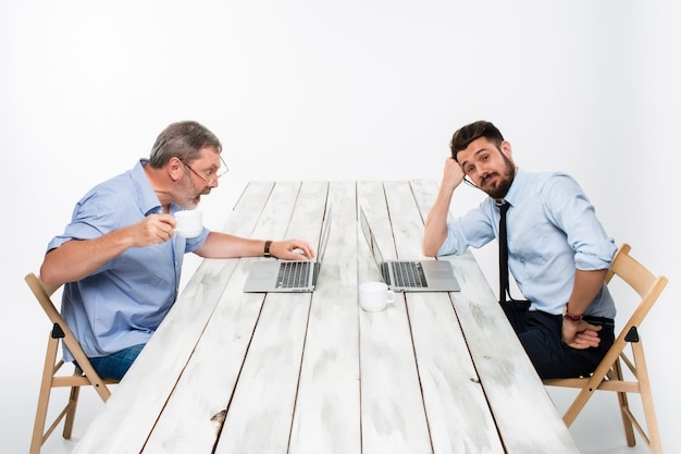 The two colleagues working together  at office on gray background