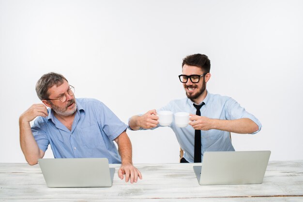 two colleagues working together at office on white