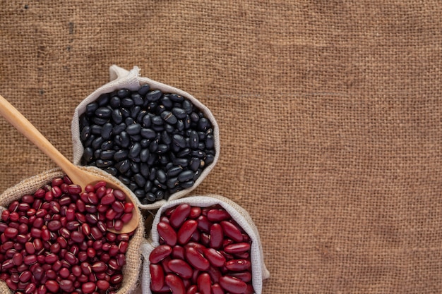 Two color bean seeds placed on a brown wood floor.