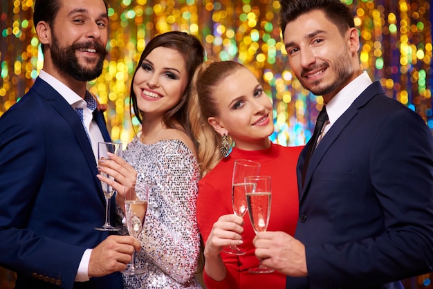 Free Photo two couples on glitter wall, celebrating the new year