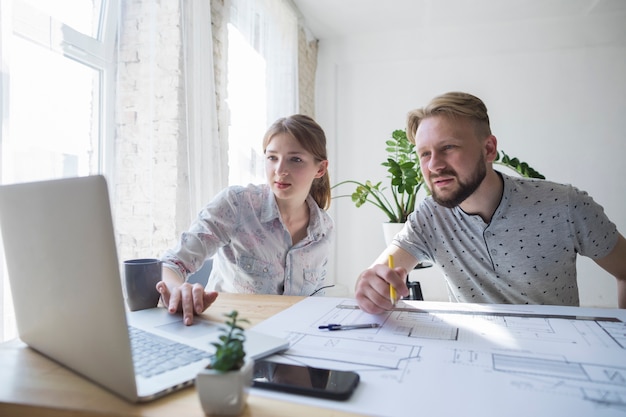 Free Photo two coworker looking at laptop while working at office