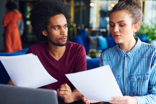 Two coworkers analyzing the documents