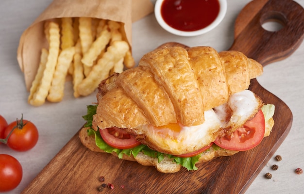 Two croissant sandwiches on wooden table, top view