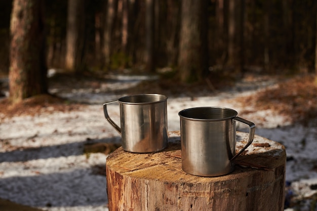 Free photo two cups of tea on the stump in forest