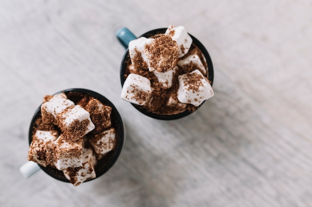 Free photo two cups with marshmallows and cocoa powder