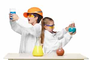 Free photo two cute children at chemistry lesson making experiments