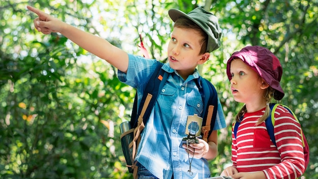 Free photo two cute kids trekking in the forest