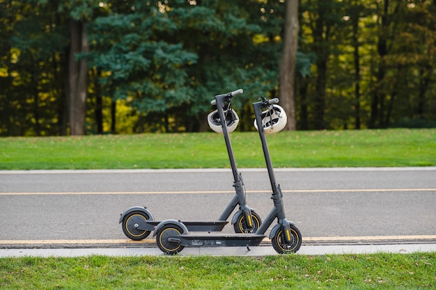 Free photo two electric kick scooters or e-scooter parked on the sidelines road