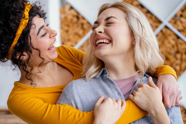 Free Photo two embraced women laughing together