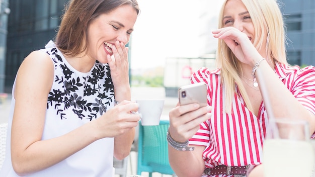 Two female friends enjoying at outdoor caf�