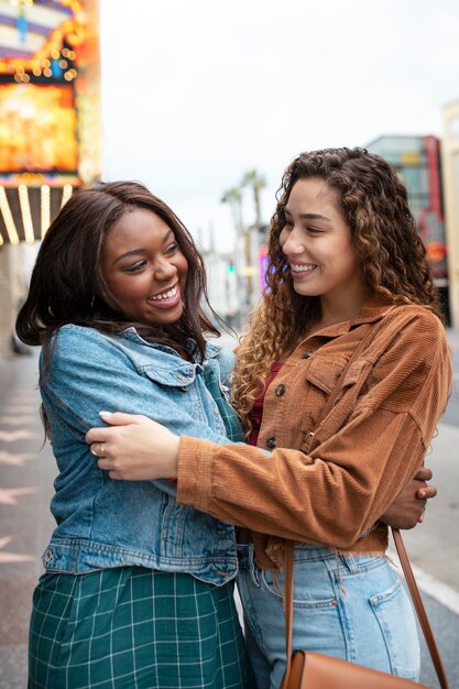 Two female friends hugging while out in the city