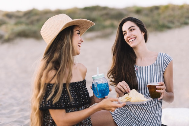 Free photo two female friends laughing at the beach