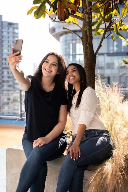 Two female friends at a rooftop terrace taking a selfie