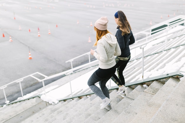 Two female jogging on the staircase in the winter