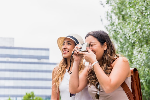 Two female traveler taking photograph from camera