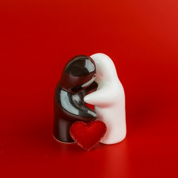 Free photo two figurines hugging on red table