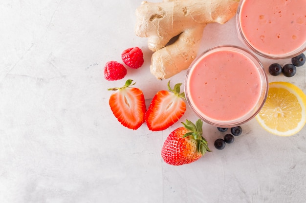 Two fresh red smoothies with ingredients