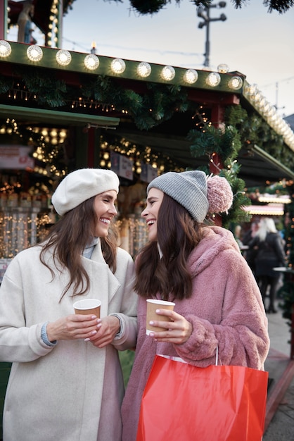 Free photo two friends having fun on christmas market