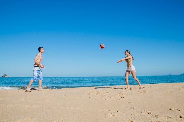 Two friends playing beach volleyball