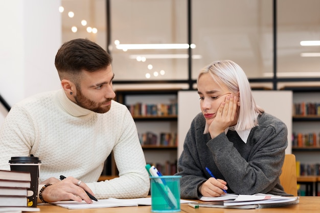 Two friends reading from a notebook during study session