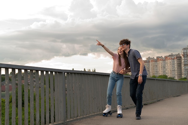 Free Photo two friends spending time together outdoors using roller skates