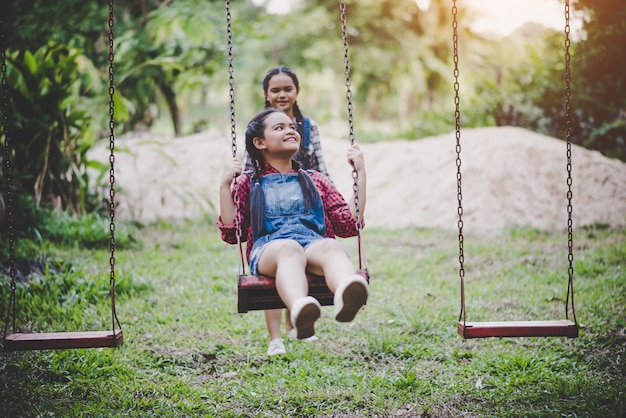 Two girl sitting on a swing together