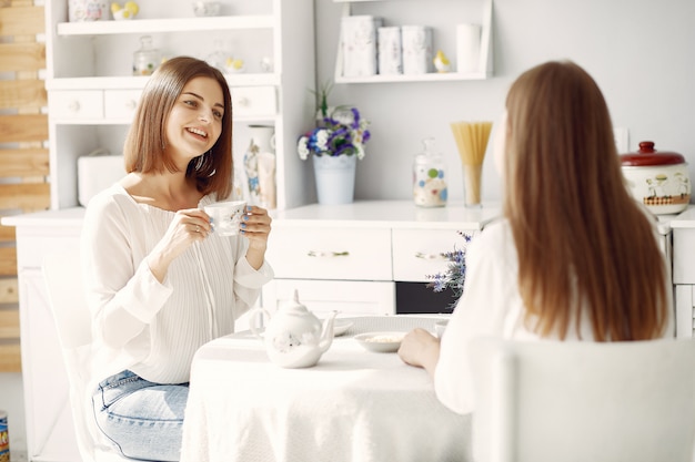 Two girlfriends drinking tea at home