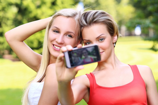 Two girls are taking photos of themselves