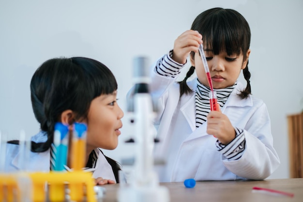 Two girls doing science experiments in a lab. Selective focus.