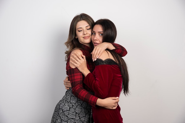 Two girls friends standing and hugging each other.